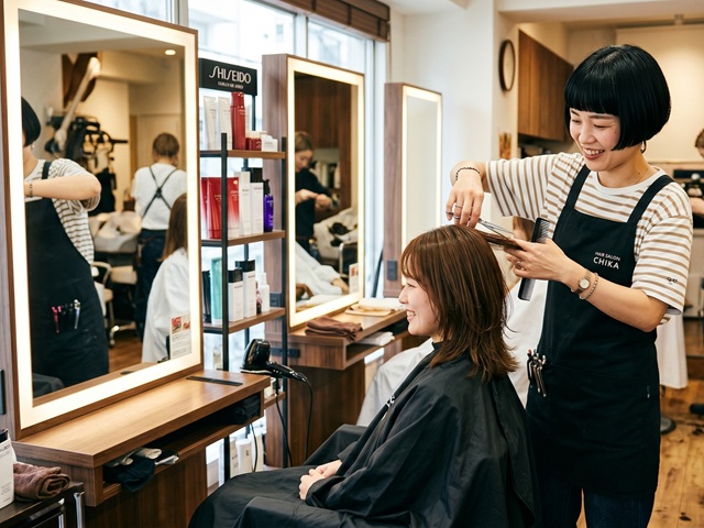 ヘアケアのアドバイスをする美容師さんが、発酵マコモ粒をお客様に勧めている様子。頭皮環境は食生活が影響するので、発酵マコモ粒は重要なアイテム。